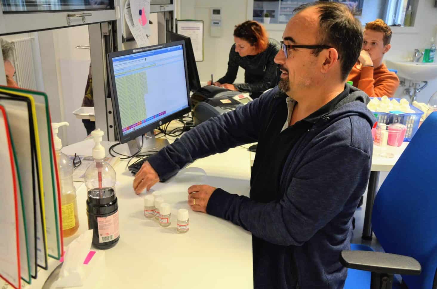 man fills little bottles with medication