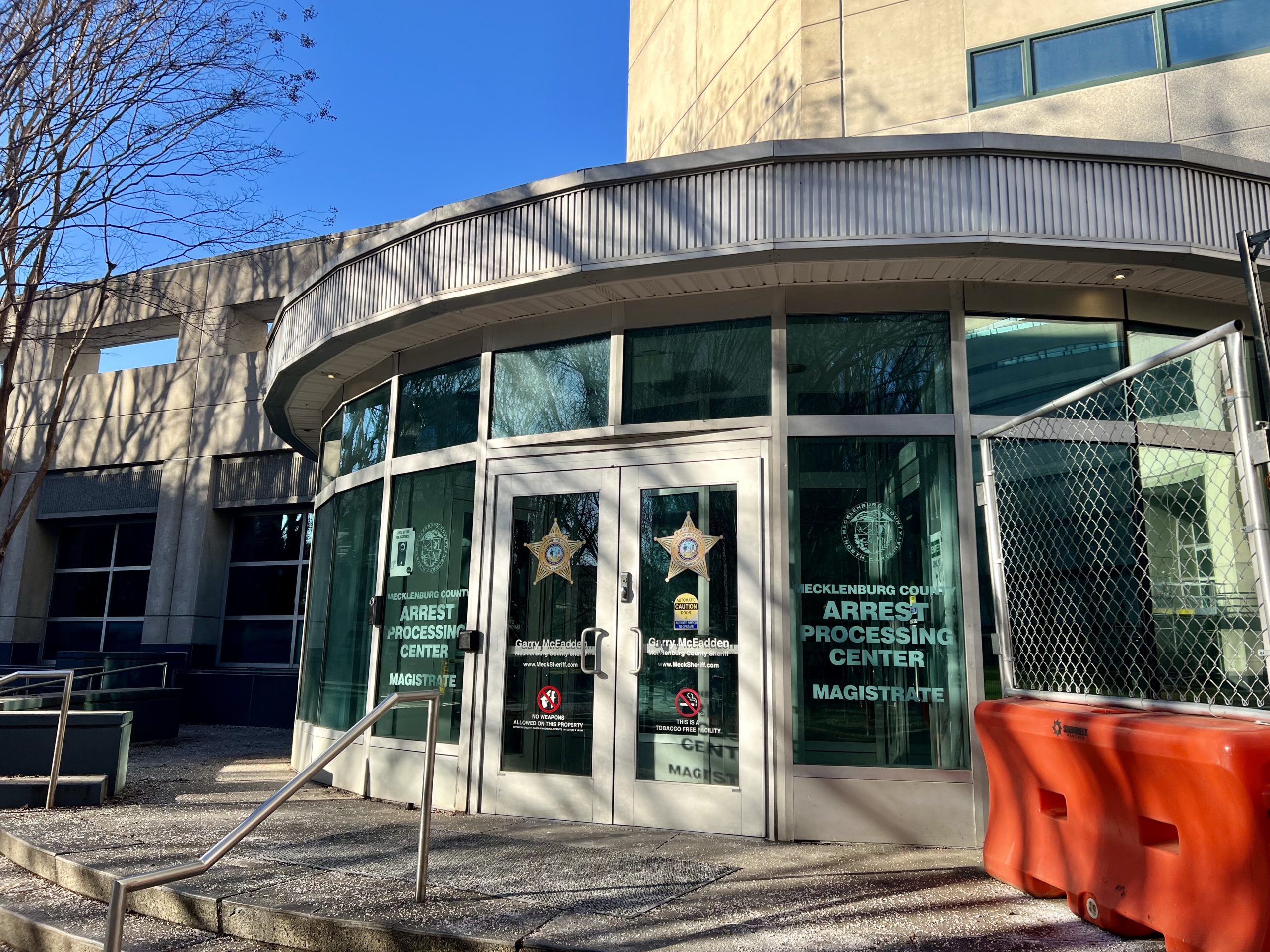 A Mecklenburg County arrest processing center. It's in the shape of a semi circle with silver siding. Construction is happening on the side