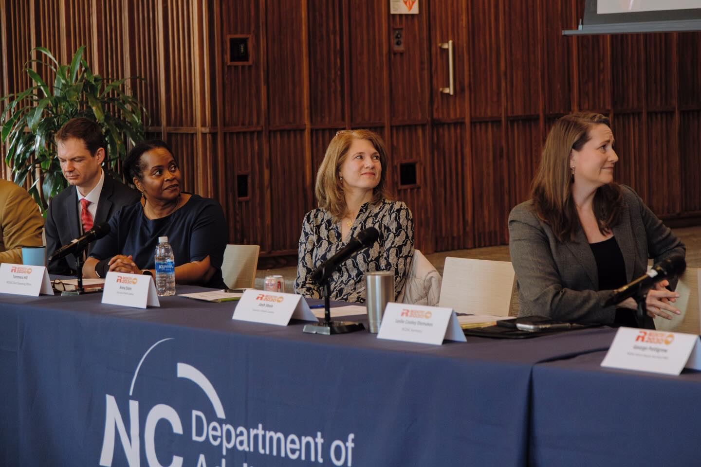 A white woman sits at a table alongside other members of the Joint Reentry Council