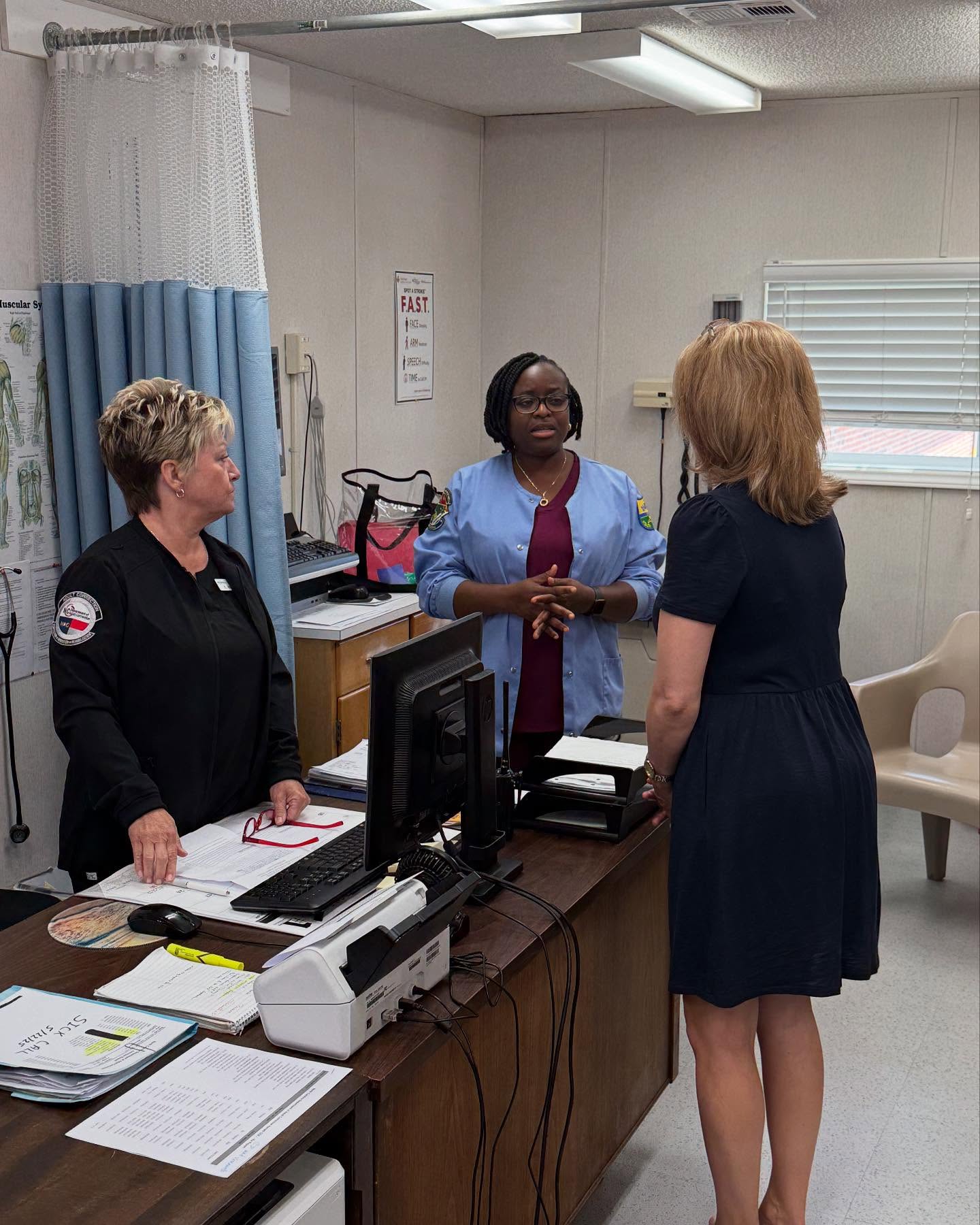 The first lady of North Carolina talks with two prison health care workers