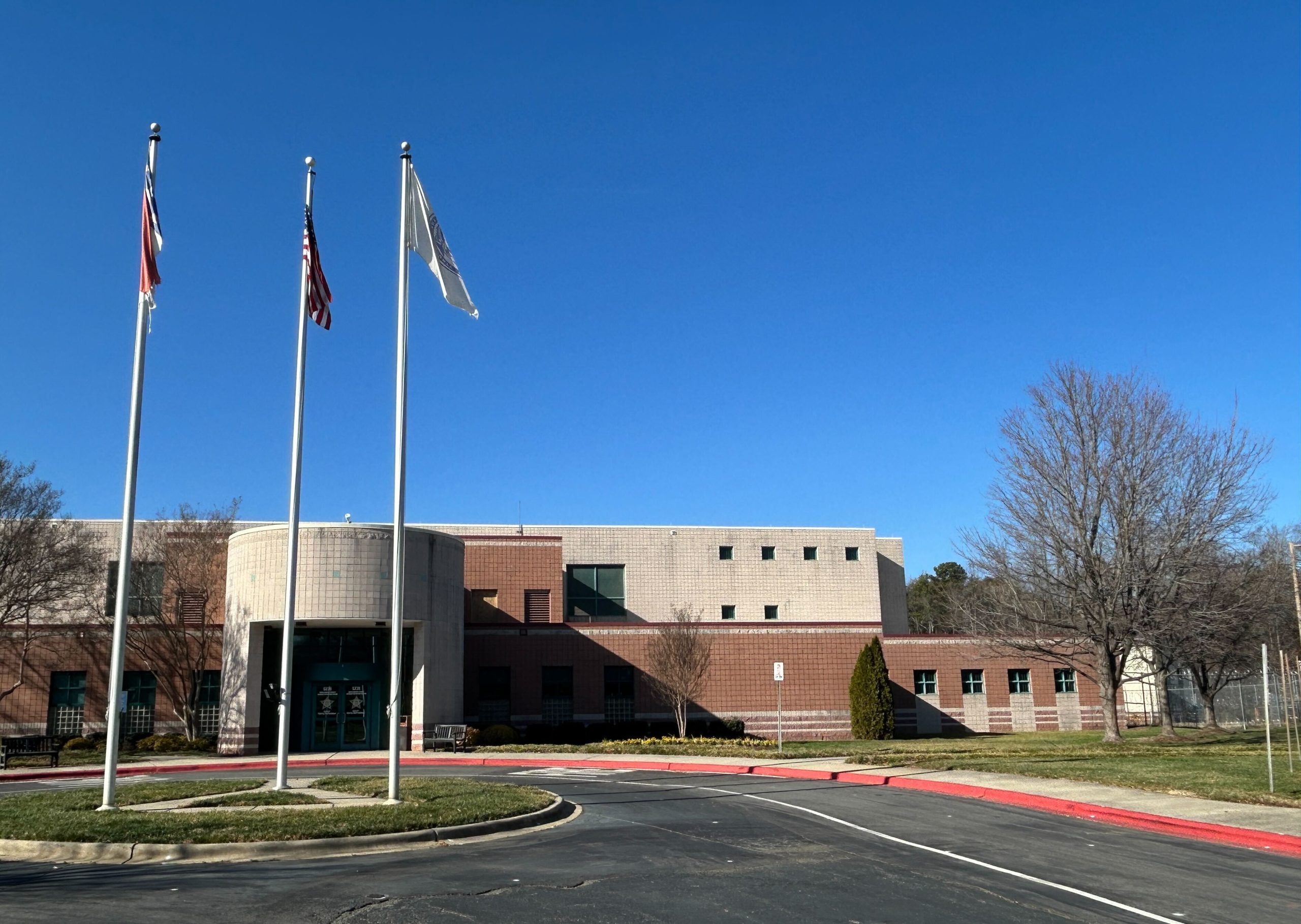 A building with flag poles in front. It is a county juvenile detention center that currently doesn't house any juveniles