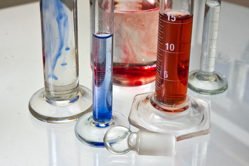 Laboratory glassware containing colored liquid samples, representing the scientific testing used in federal chemical risk evaluations.