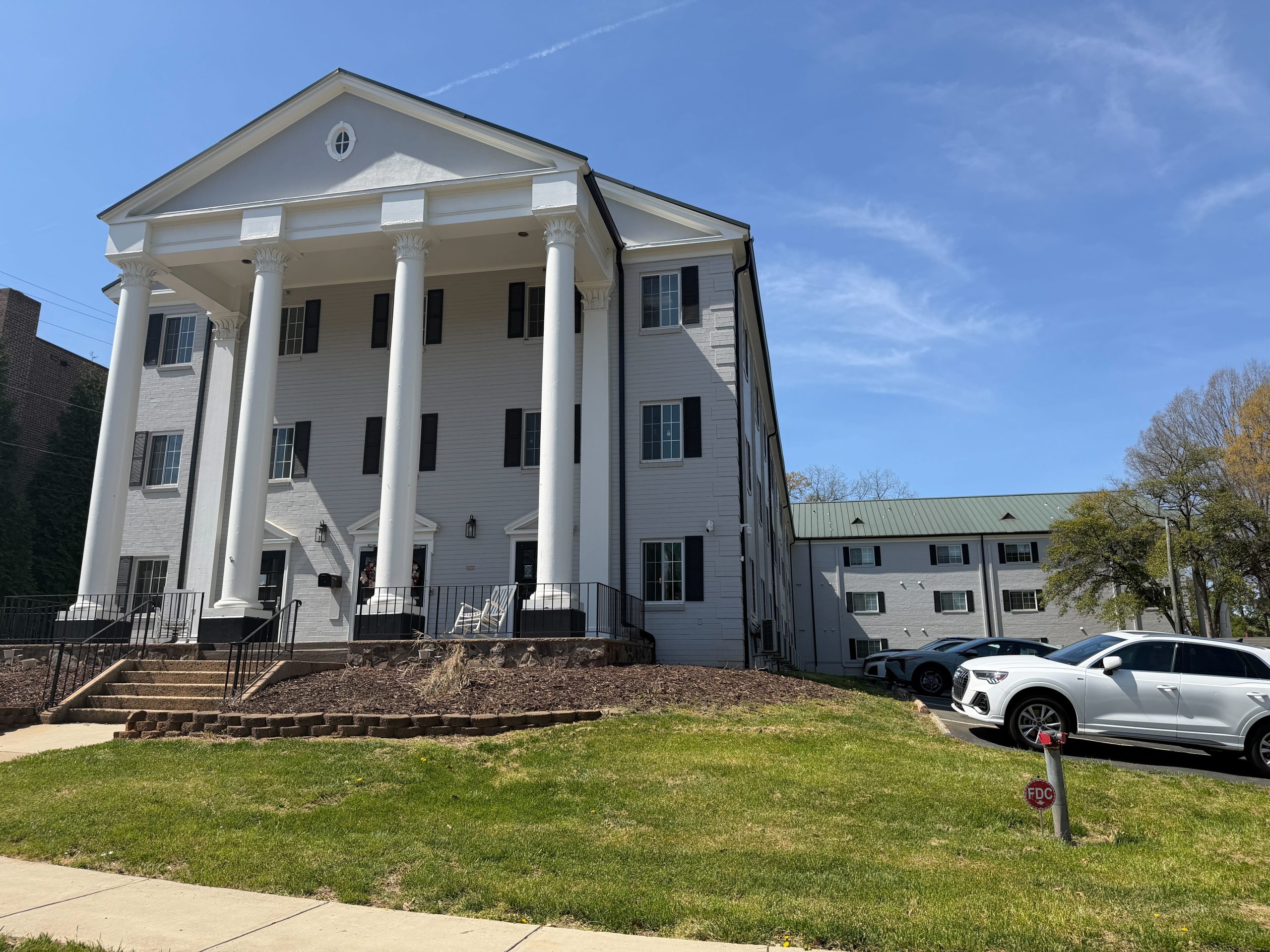 Shows a three story nursing home facility facade with high columns. The facility is located in Mecklenburg County 