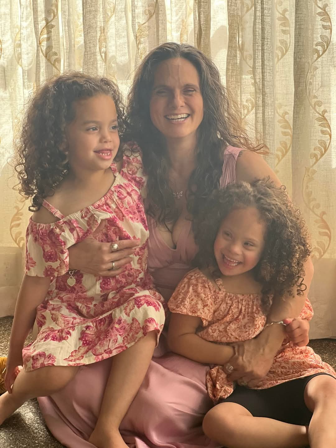 A mother hugging her two young kids